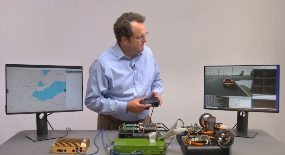 nxp半导体公司的Curt Hillier控制着一个H E V处理器在环仿真，同时观看车辆的三维仿真。