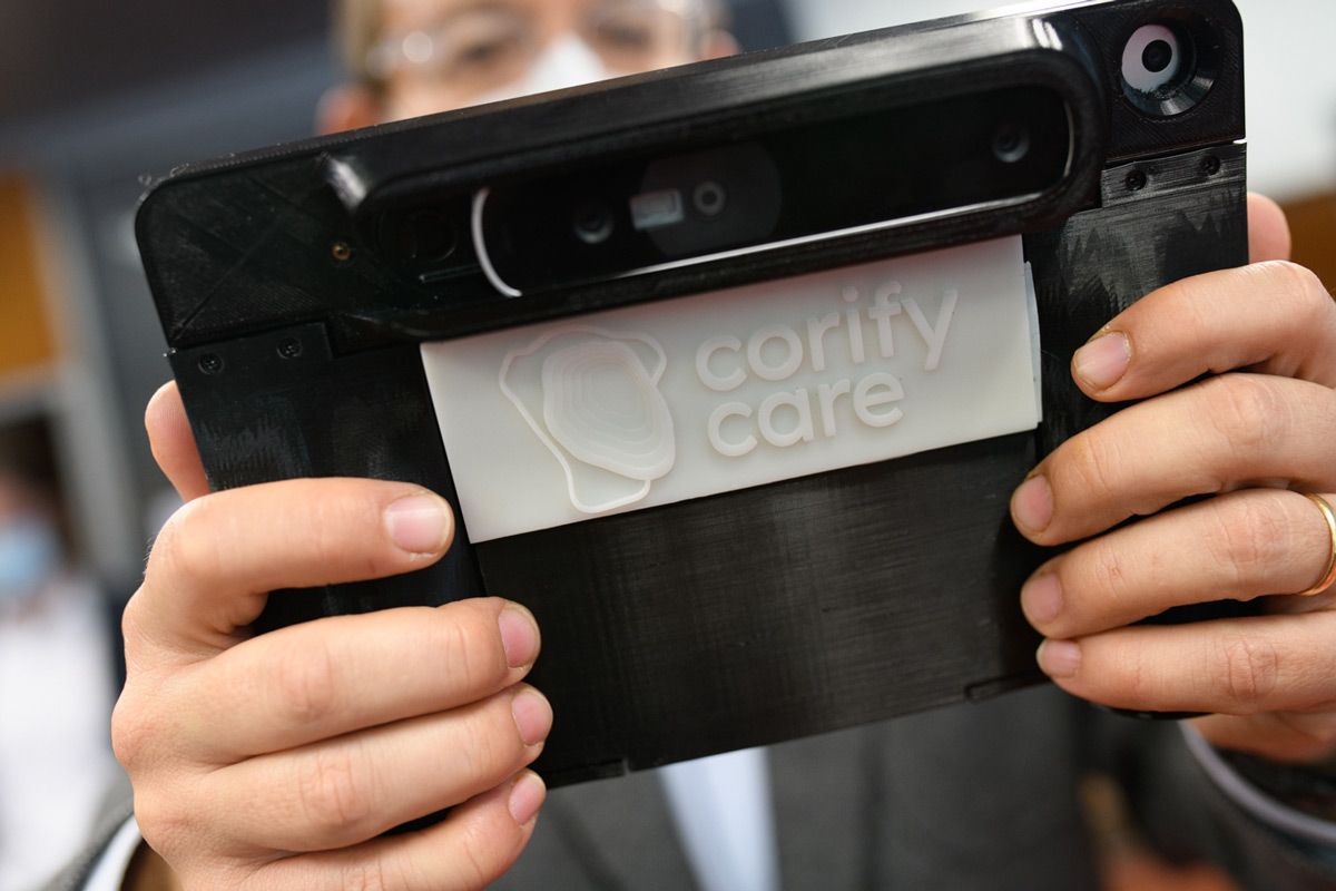Corify Care Acorys扫描系统由一个正在展示所附3D相机的人持有。