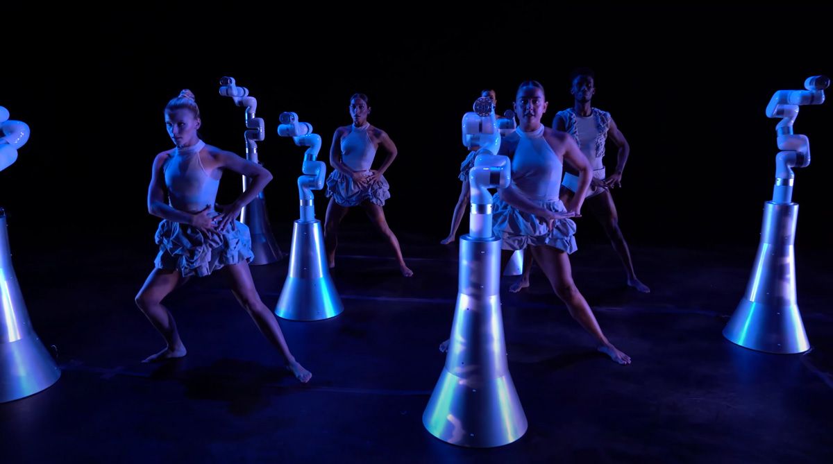 六个舞者和六个机器人在舞台上表演。